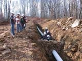 Photo from Sedimentation and Stratigraphy field trip showing students around an in-ground pipeline installation