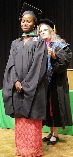 Professor Lawrence puts a graduation hood on Elizabeth Otunuga