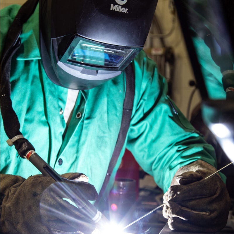 A welding student works on a project