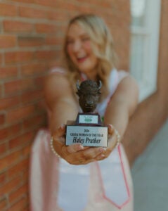 Haley Prather smiles with her Marshall University Greek Woman of the Year trophy