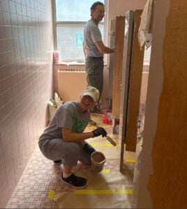 Sandra Morris volunteers by painting a restroom Buskirk Hall during Marshall's Community Cares Week in 2022