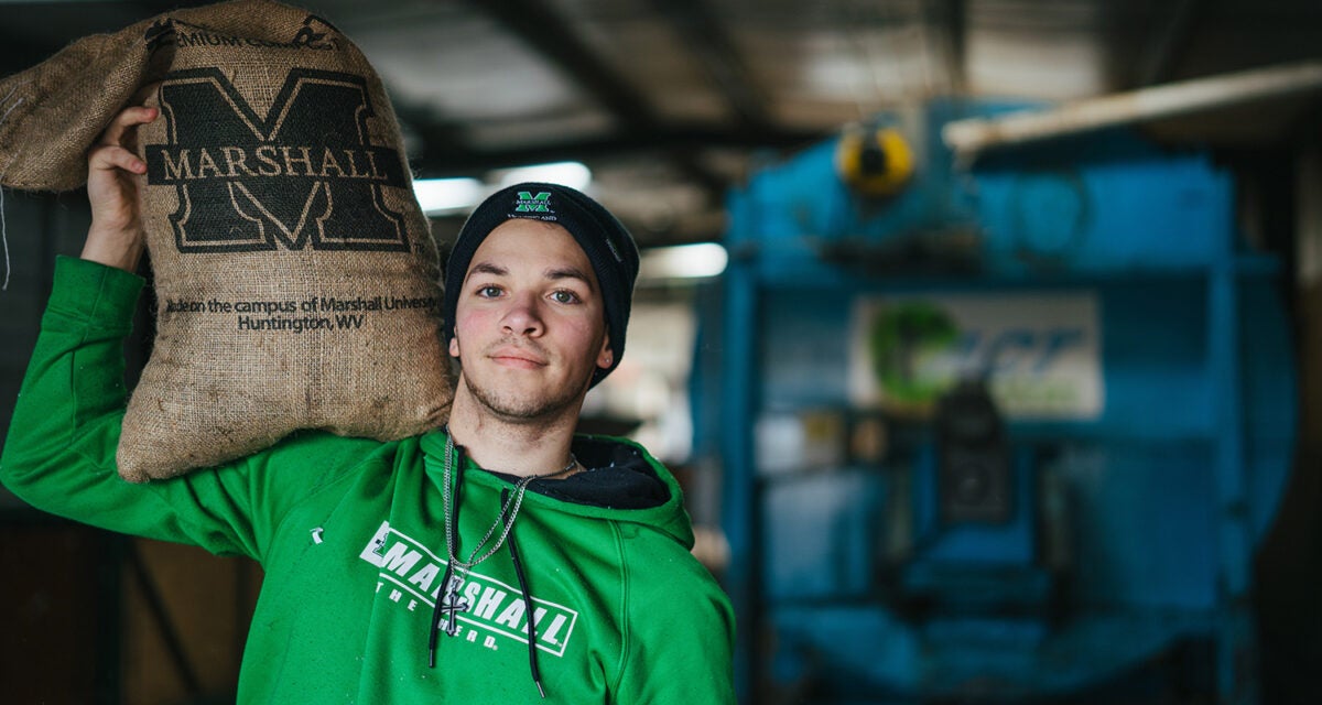 A staff member carries a bag of Herd Dirt at Marshall University's Compost Facility