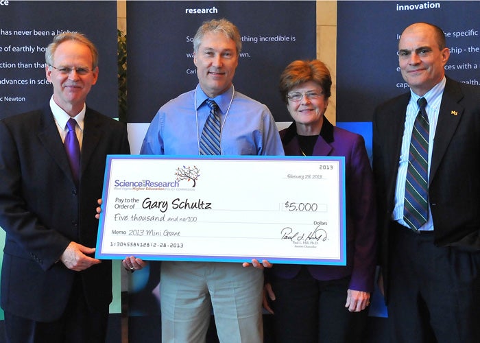 Photo of Dr. Gary Schultz receiving a giant check representing his grant award