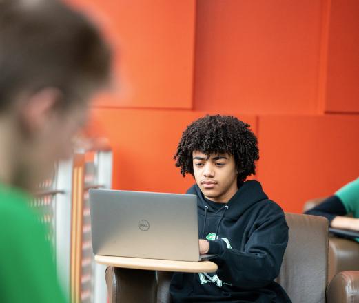 student on laptop in the library
