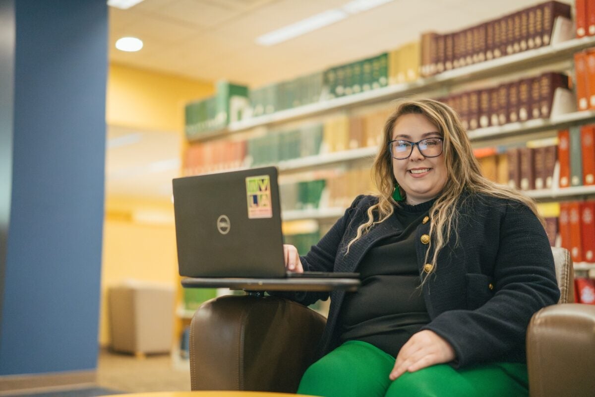 student working on a laptop in the library
