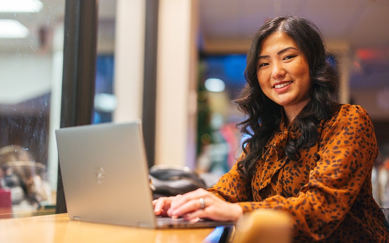 Student working at a computer in a coffee shop setting