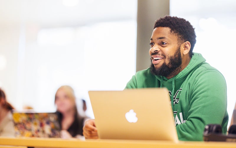 Student wearing a Marshall sweatshirt in a classroom.