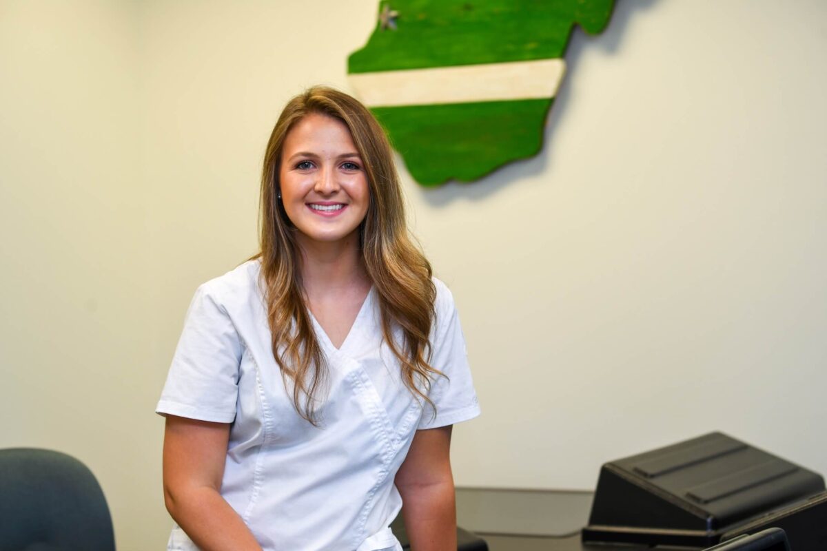 student smiling and looking at the camera in nursing scrubs