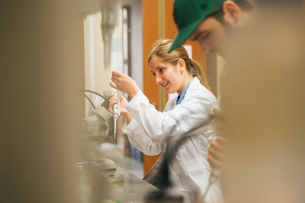 two students working in a lab and smiling