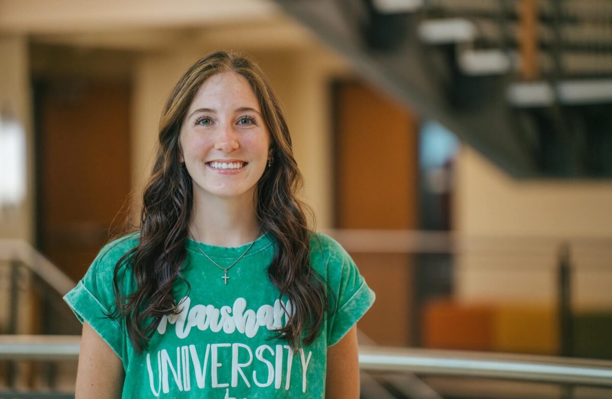 student looking at the camera and smiling in the engineering building