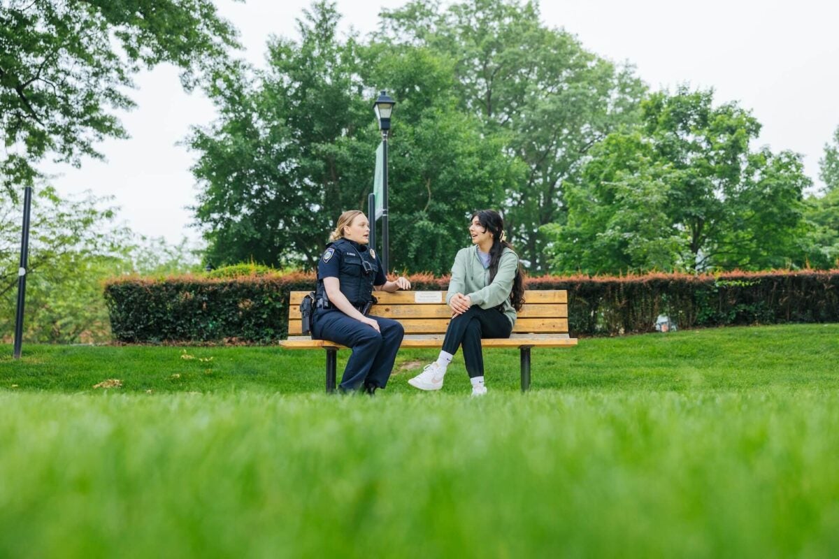police officer talking to a student outside on campus