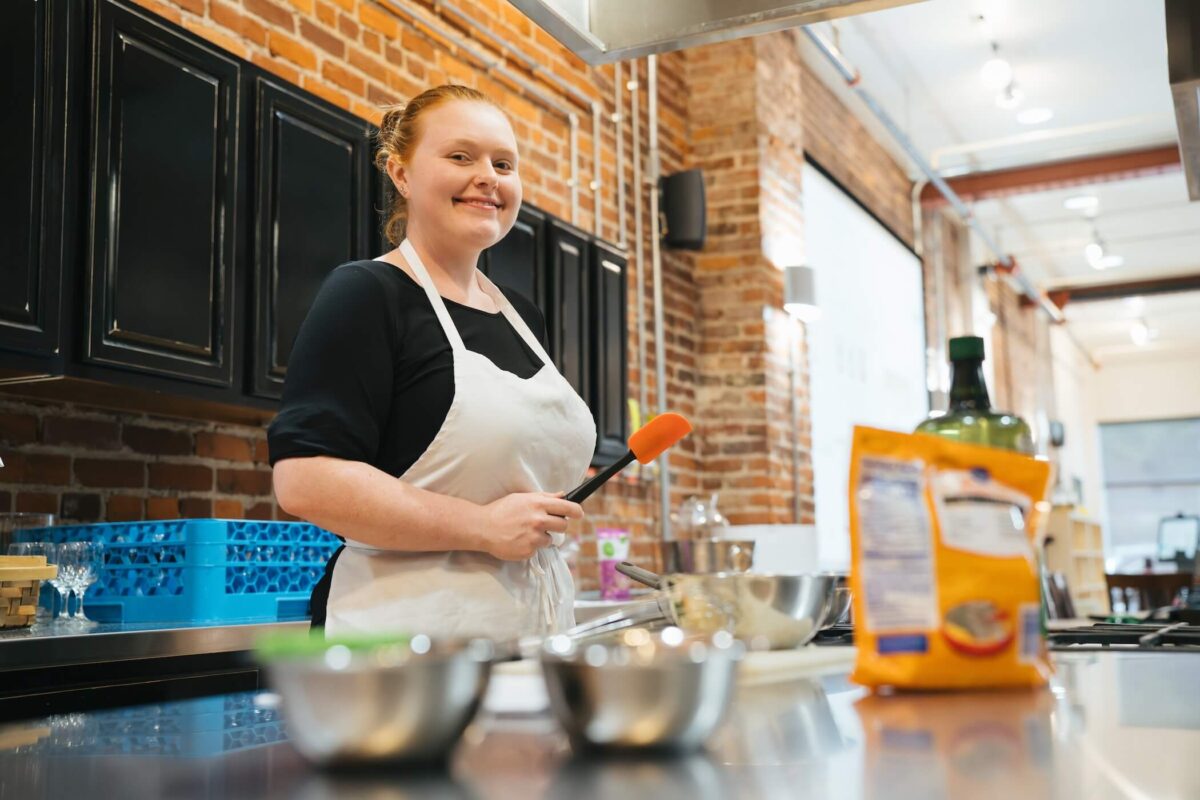 student getting ready to cook in a dietetics lab, smiling at the camera