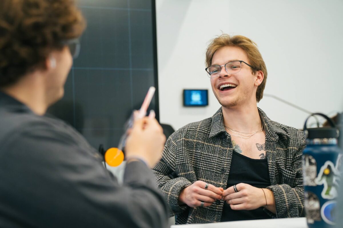 two students talking and laughing in a classroom