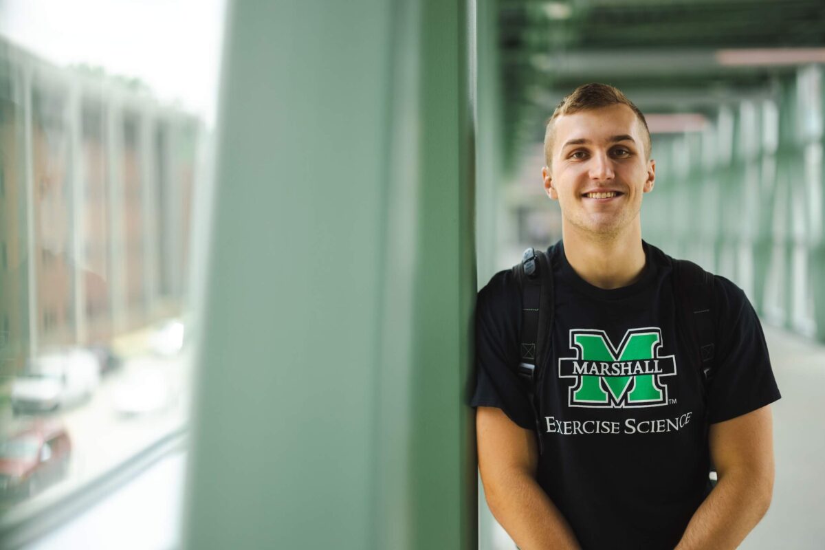 student smiling at the camera in an exercise science tshirt