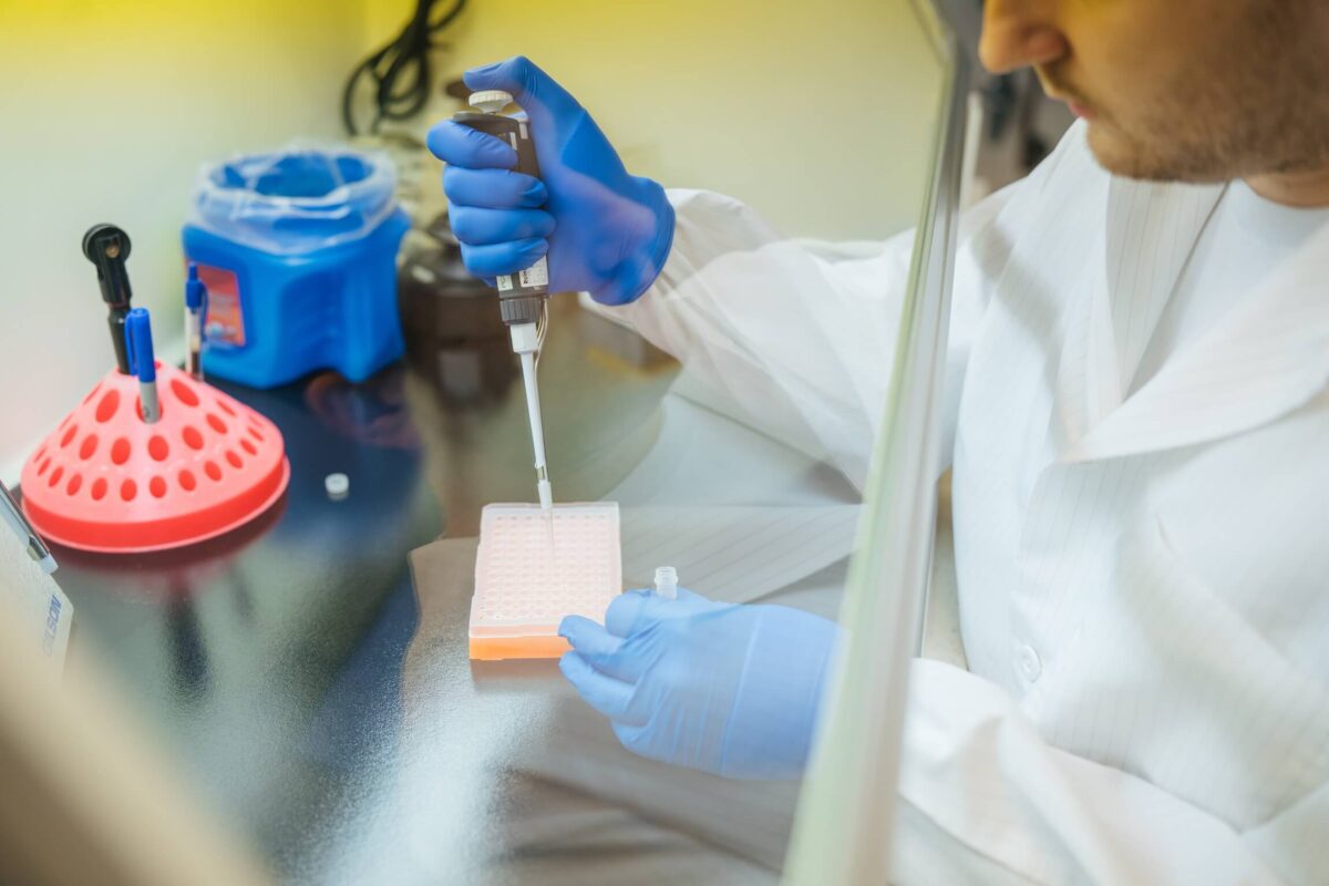 student's hand working in a lab on test samples