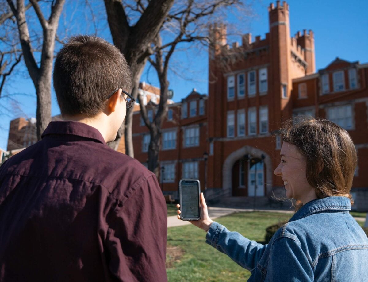 two students using the Clio app outside of Old Main