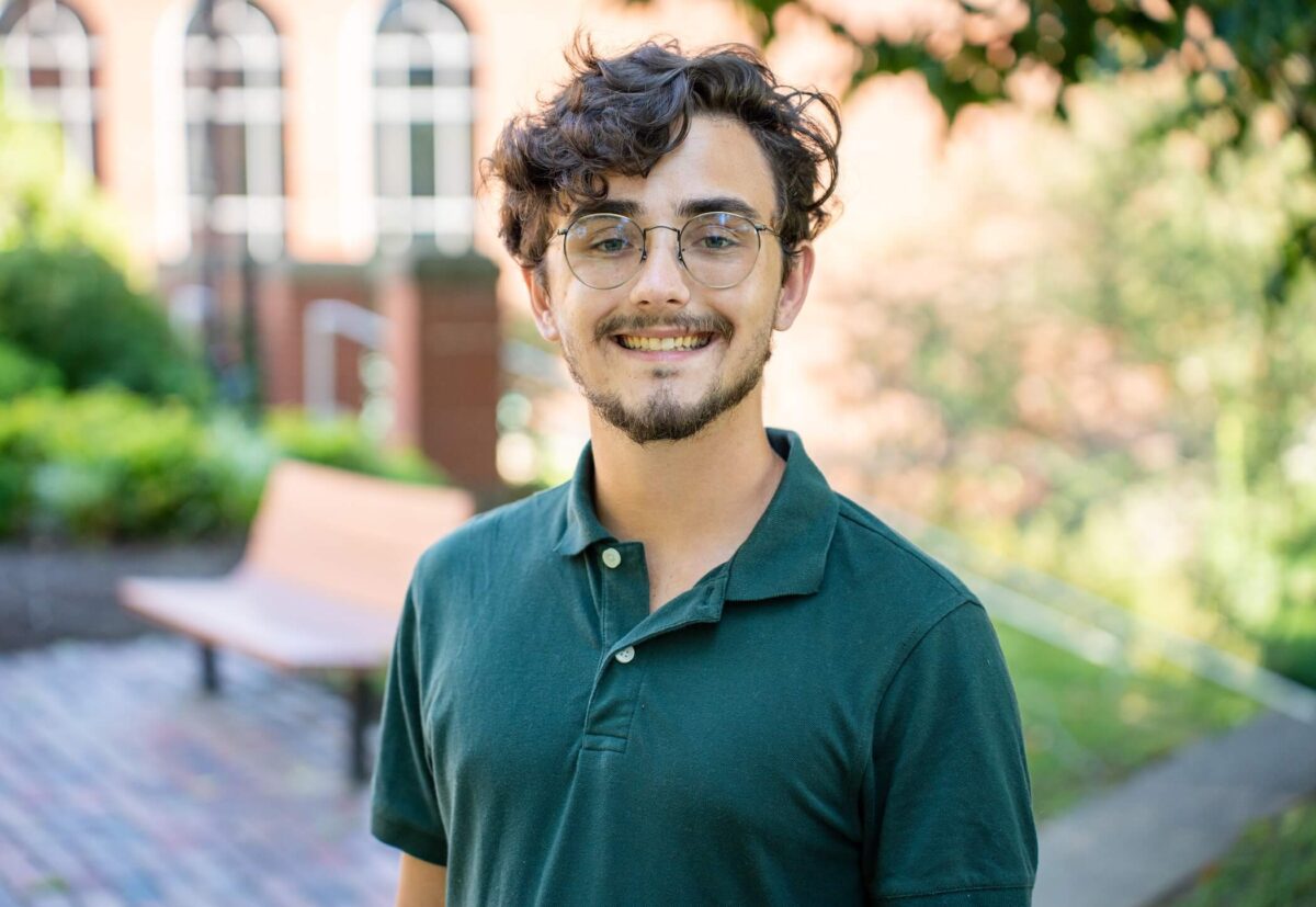 student standing outside Morrow Library and smiling at the camera