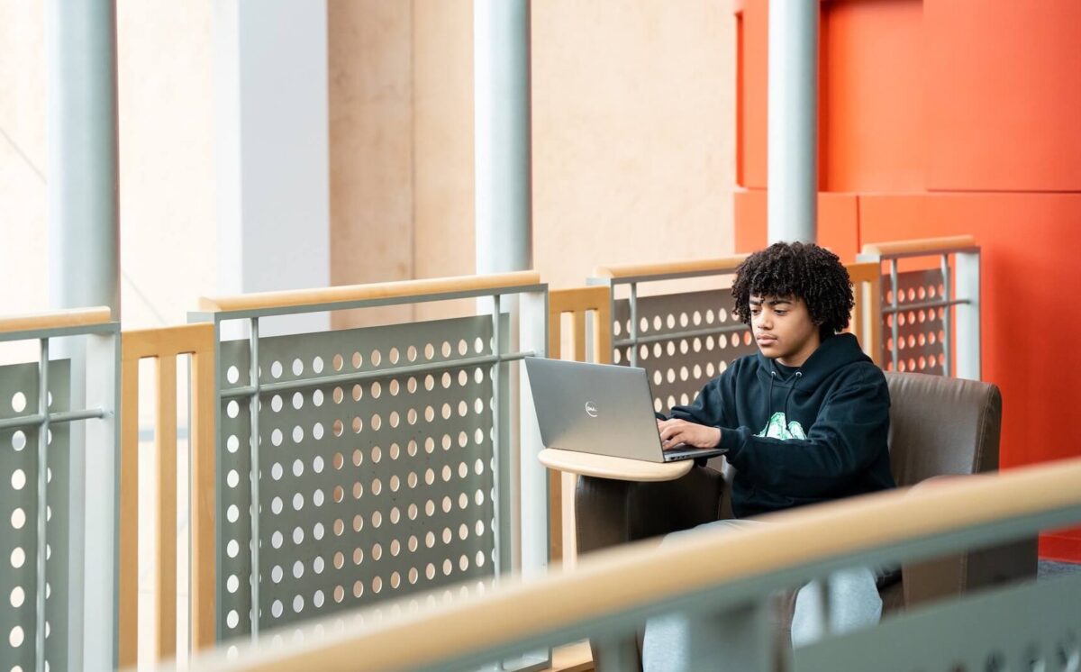 student working on a laptop in Drinko Library
