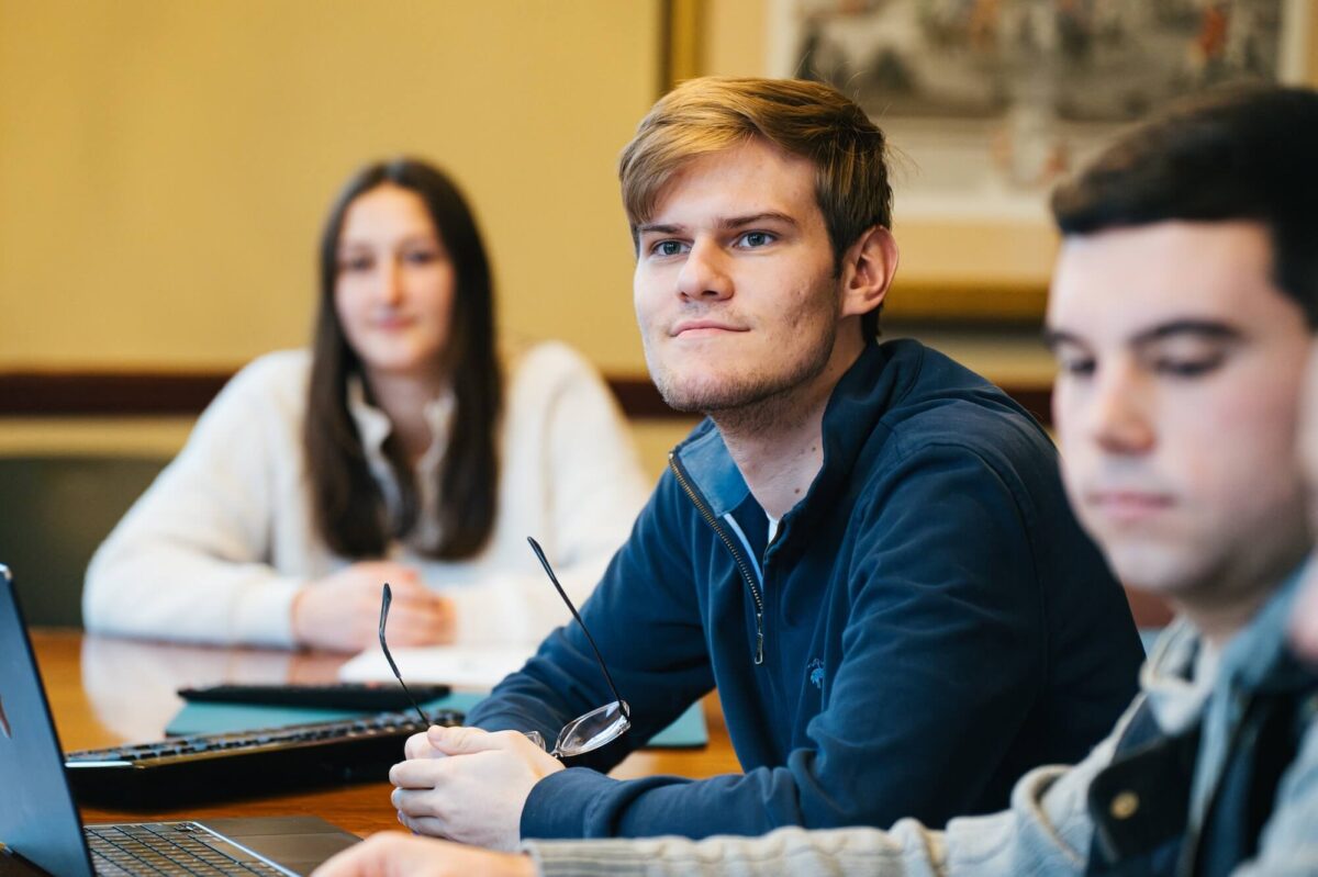 three students listening to a lecture in class