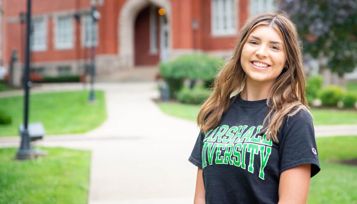 student smiling at the camera outside of Old Main
