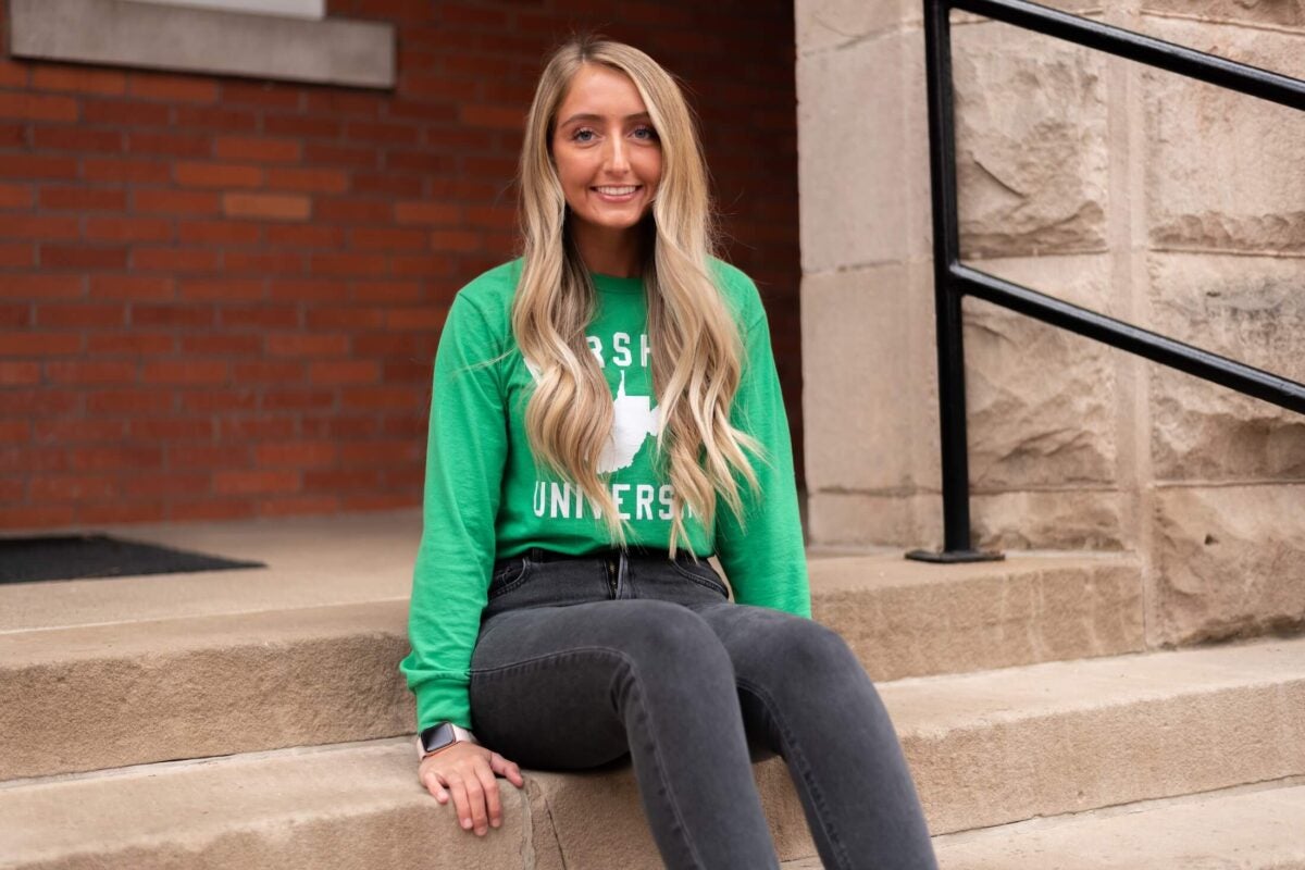 student sitting on steps outside of Old Main