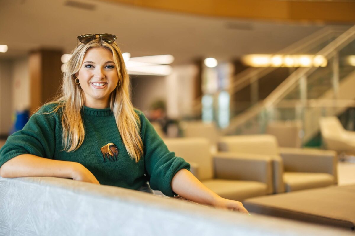 student smiling at the camera inside the Memorial Student Center