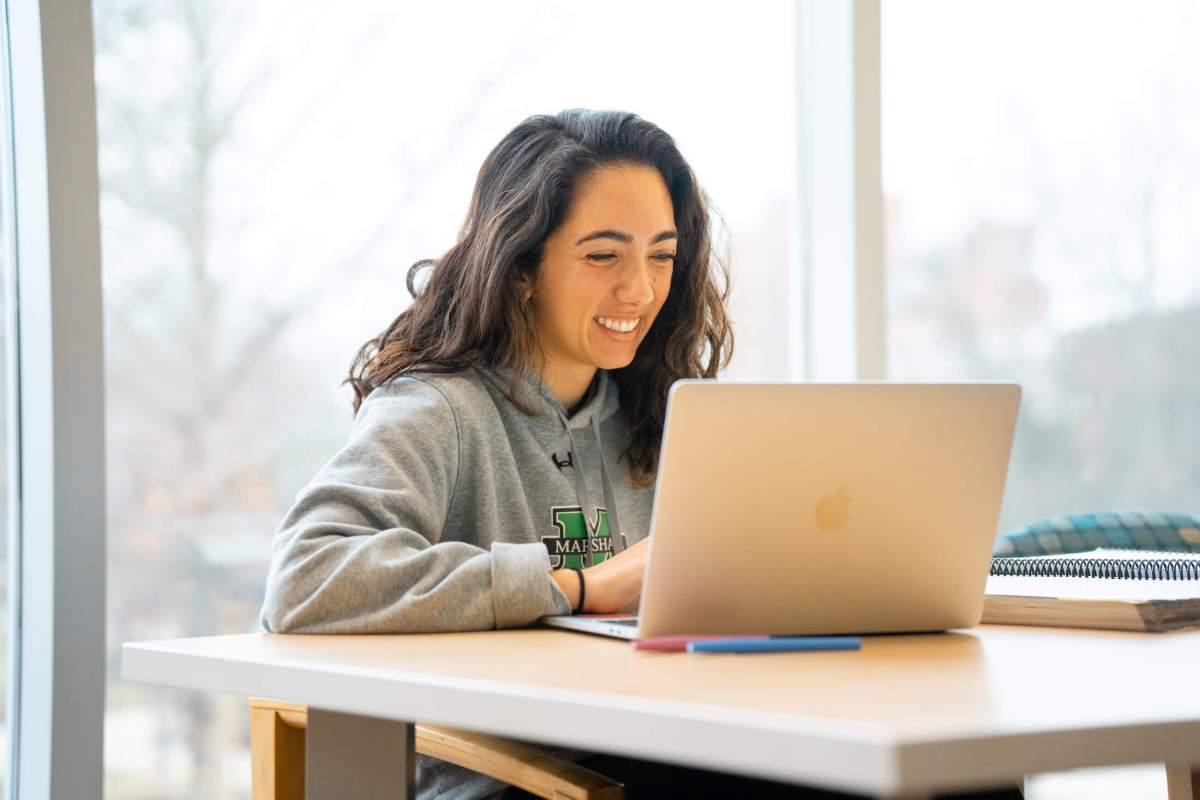 student working on a laptop inside the library