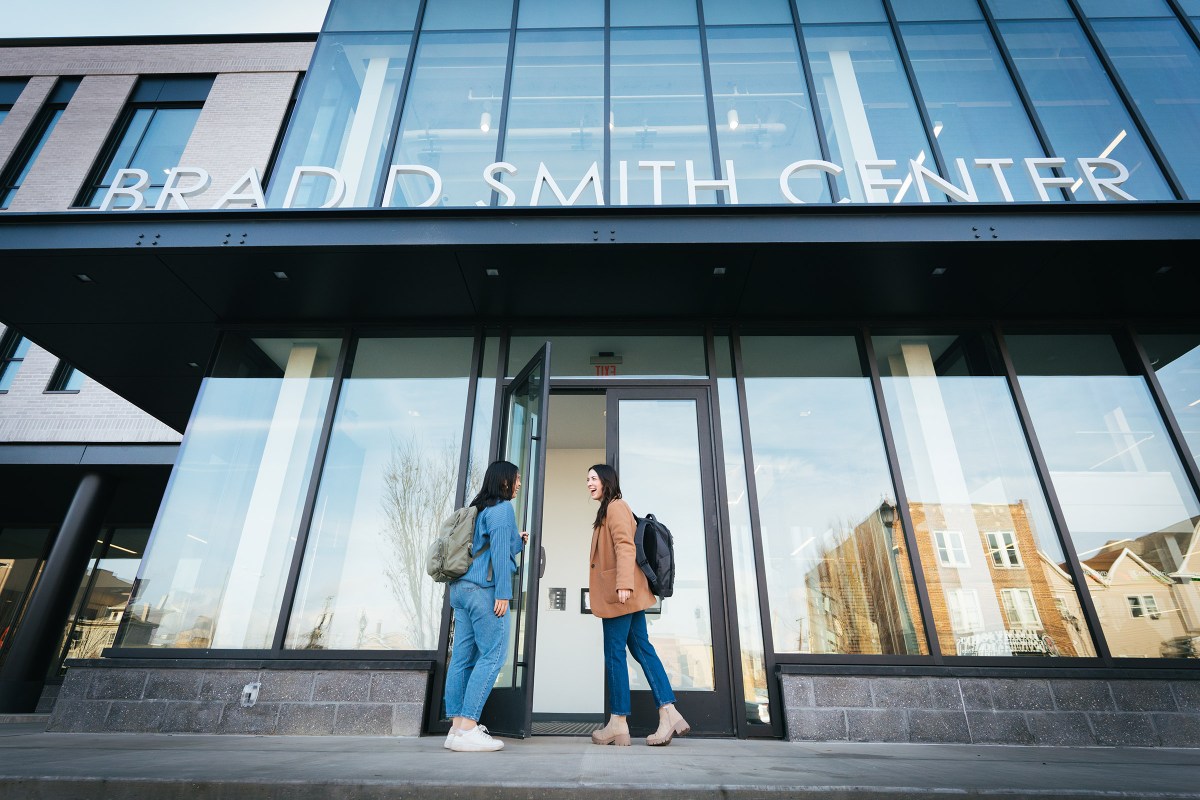 Two students smile at each other as they walk into Marshall University's Brad D. Smith Center for Business and Innovation