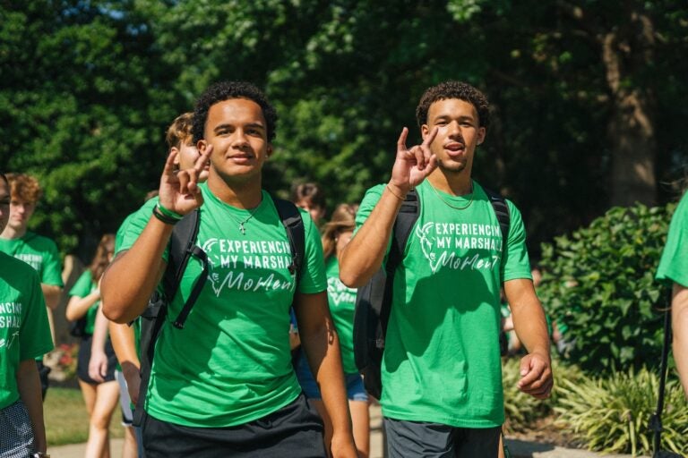 two male students walking to freshmen convocation