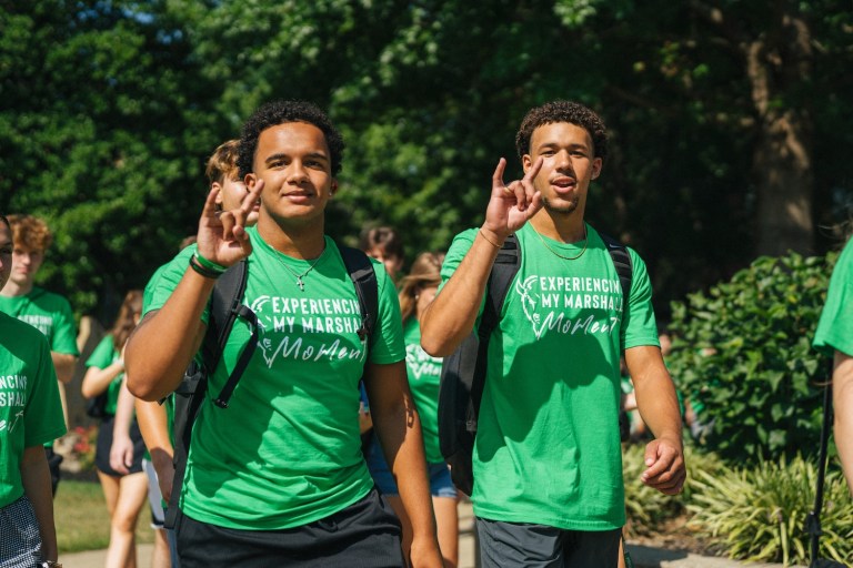 two male students walking to freshmen convocation