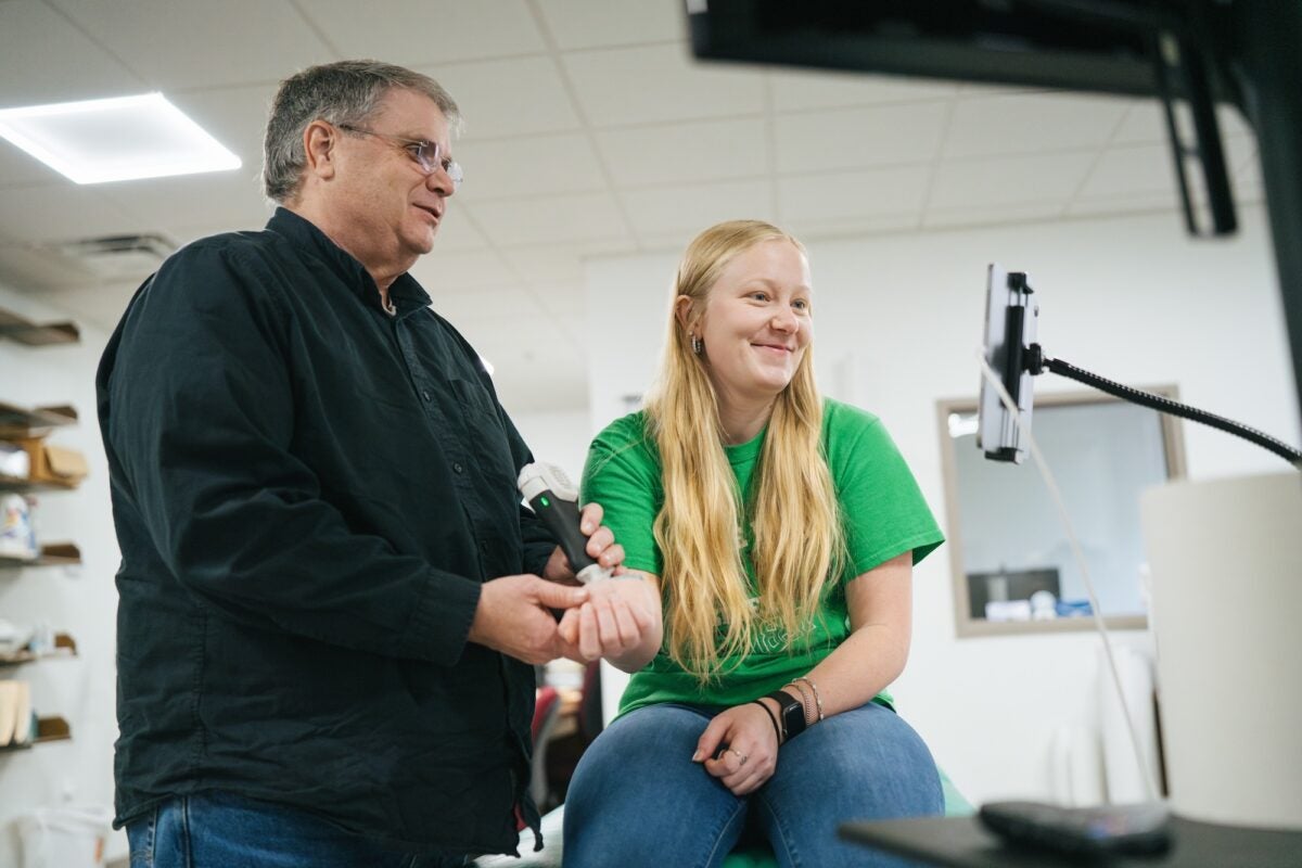 student getting an ultrasound on their hand by a professor