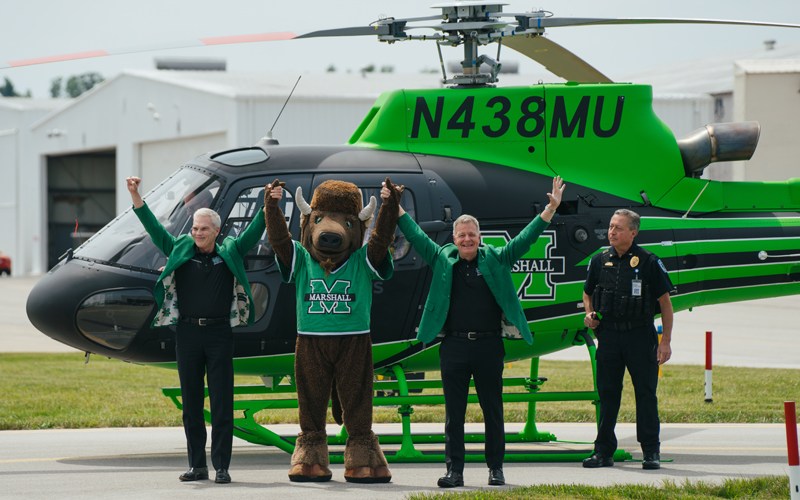 Marshall University president, Brad D. Smith, Marco and Bill Noe, Marshall University's Chief Aviation officer join heads in celebration of the delivery of Marshall's new branded helicopter
