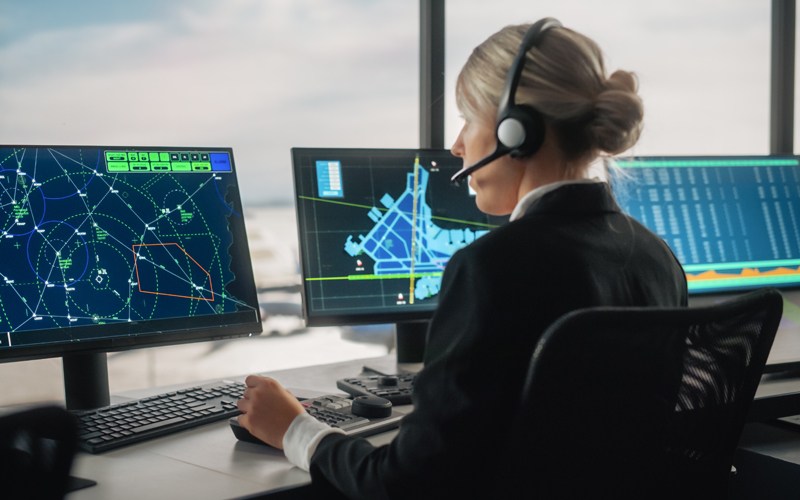 Aircraft Dispatcher works on a computer from an airport tower.