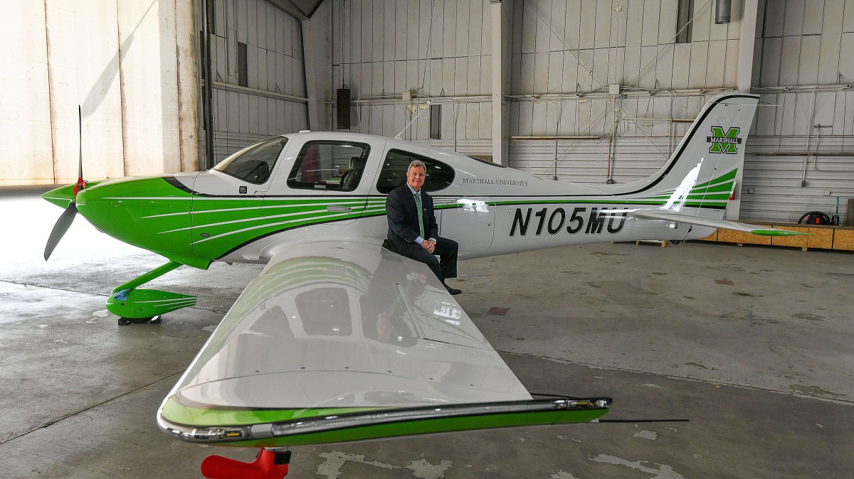 Bill Noe sits on the wing of a Marshall branded plane