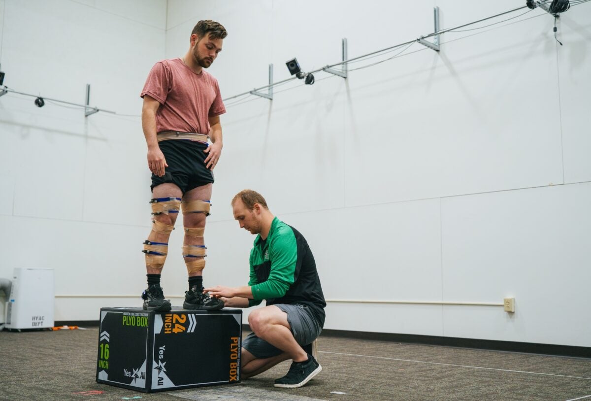 student measuring another student in the biomechanics-dev lab
