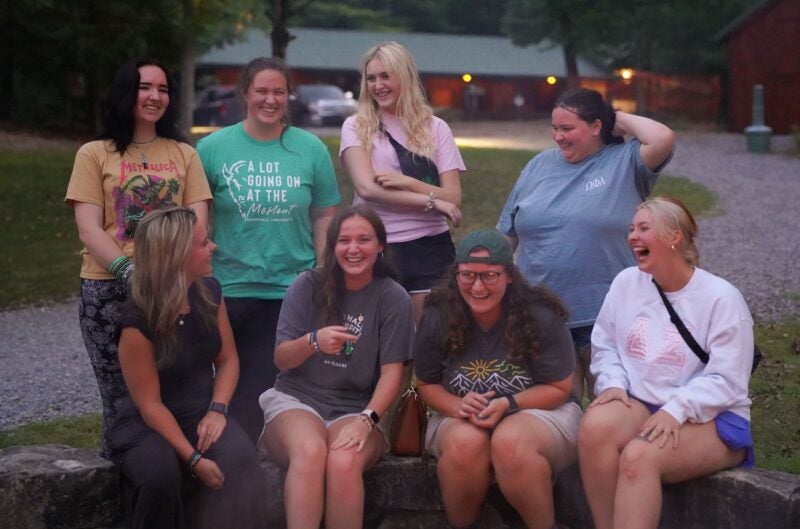group of BOLD Scholars laughing around a fire