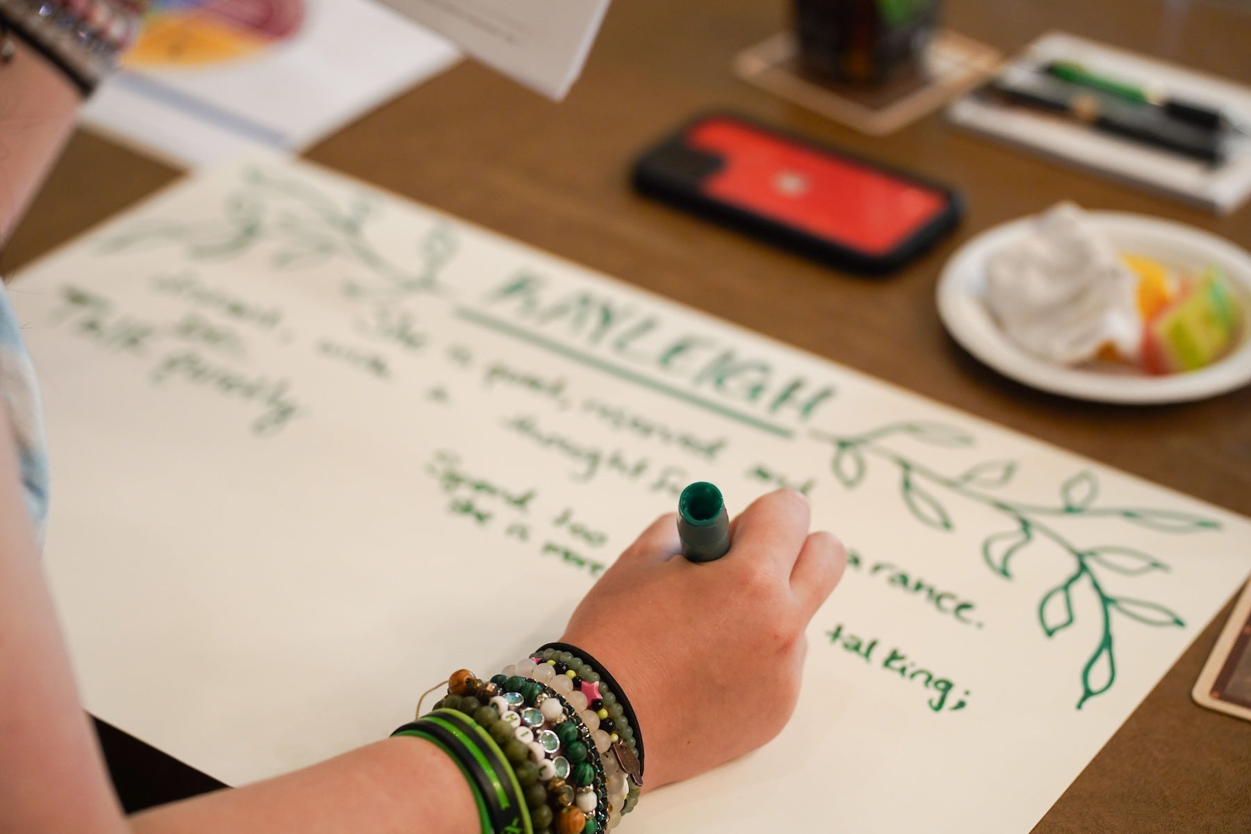 Scholar writing their name and personality traits on a poster