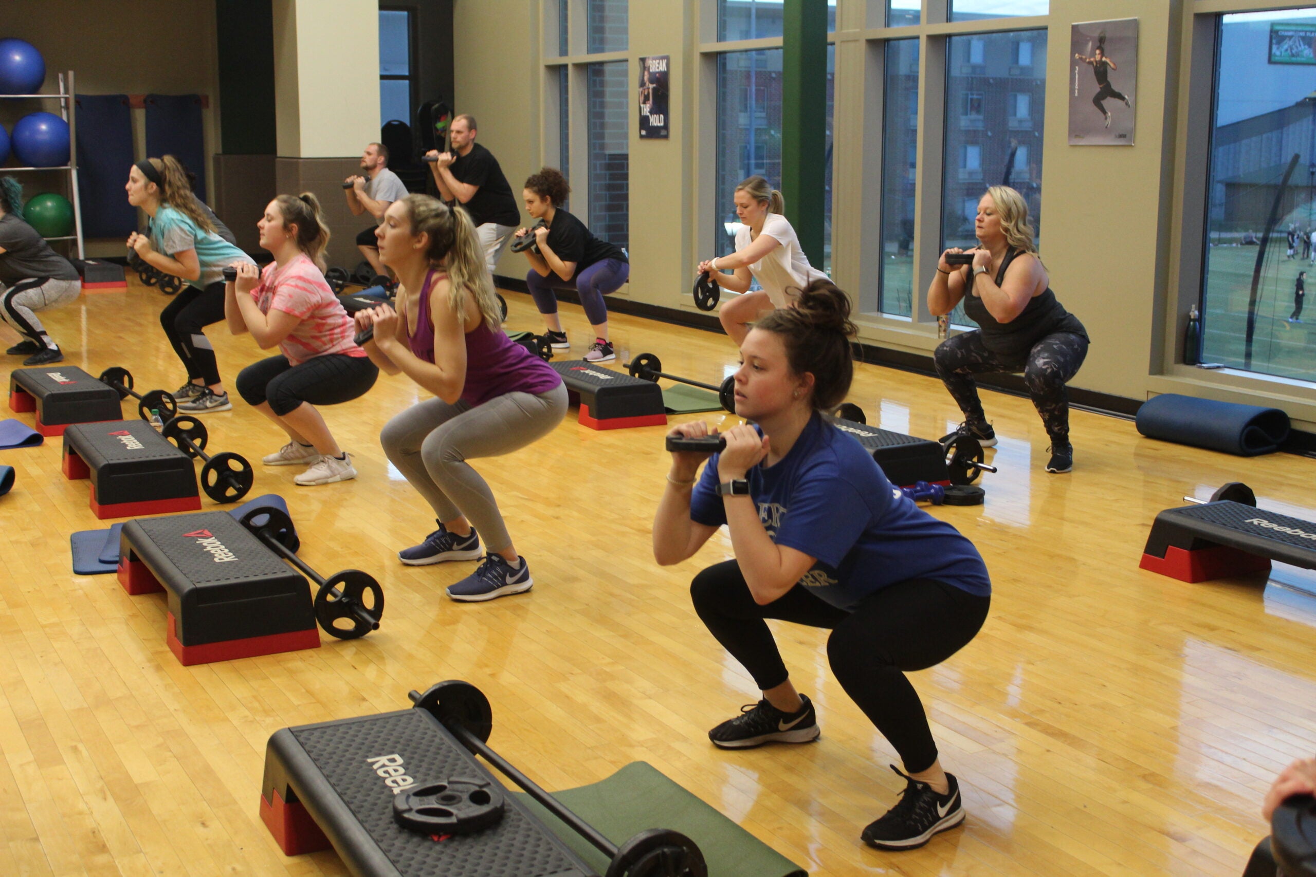 Image of female students in a fitness class lifting weights