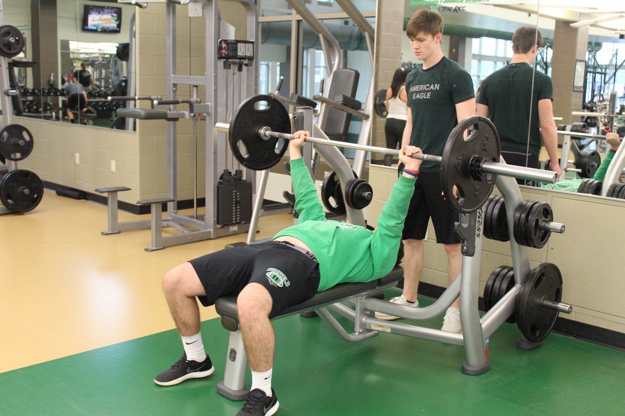 Image of male students lifting weights