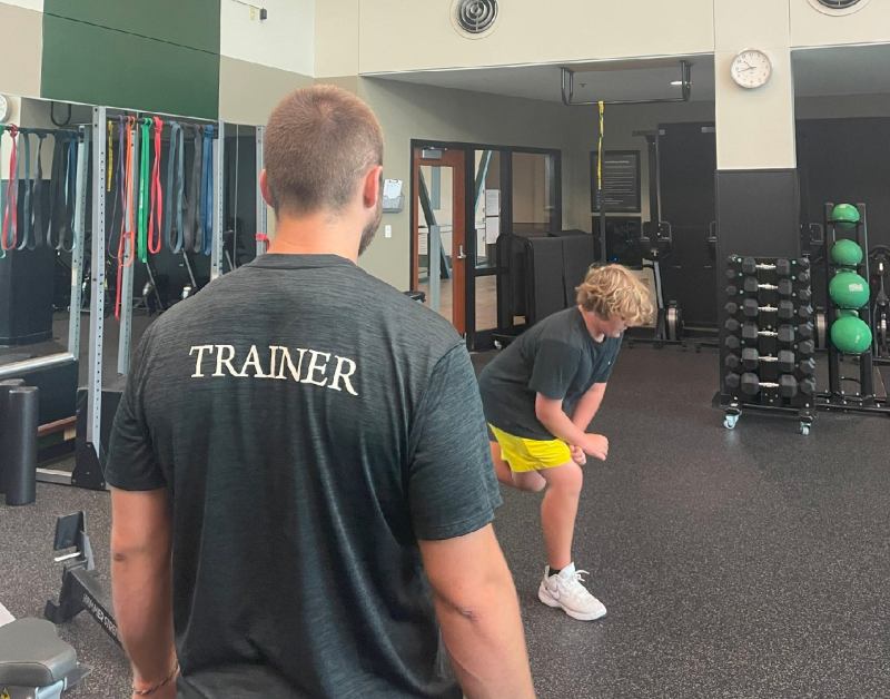 Image of personal trainer working with young male