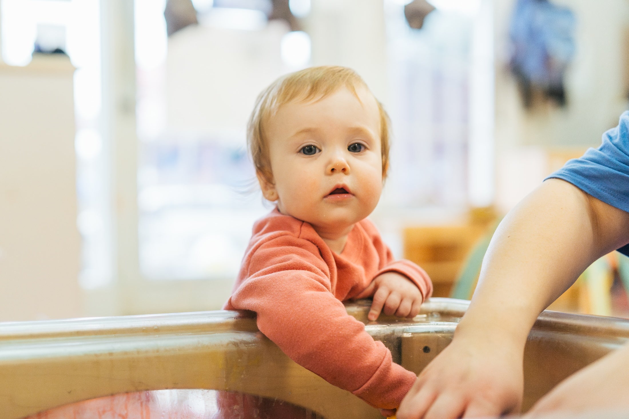 infant standing by a messy table
