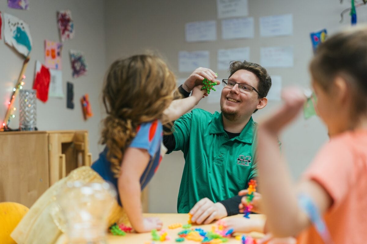 students playing with a teacher at a table