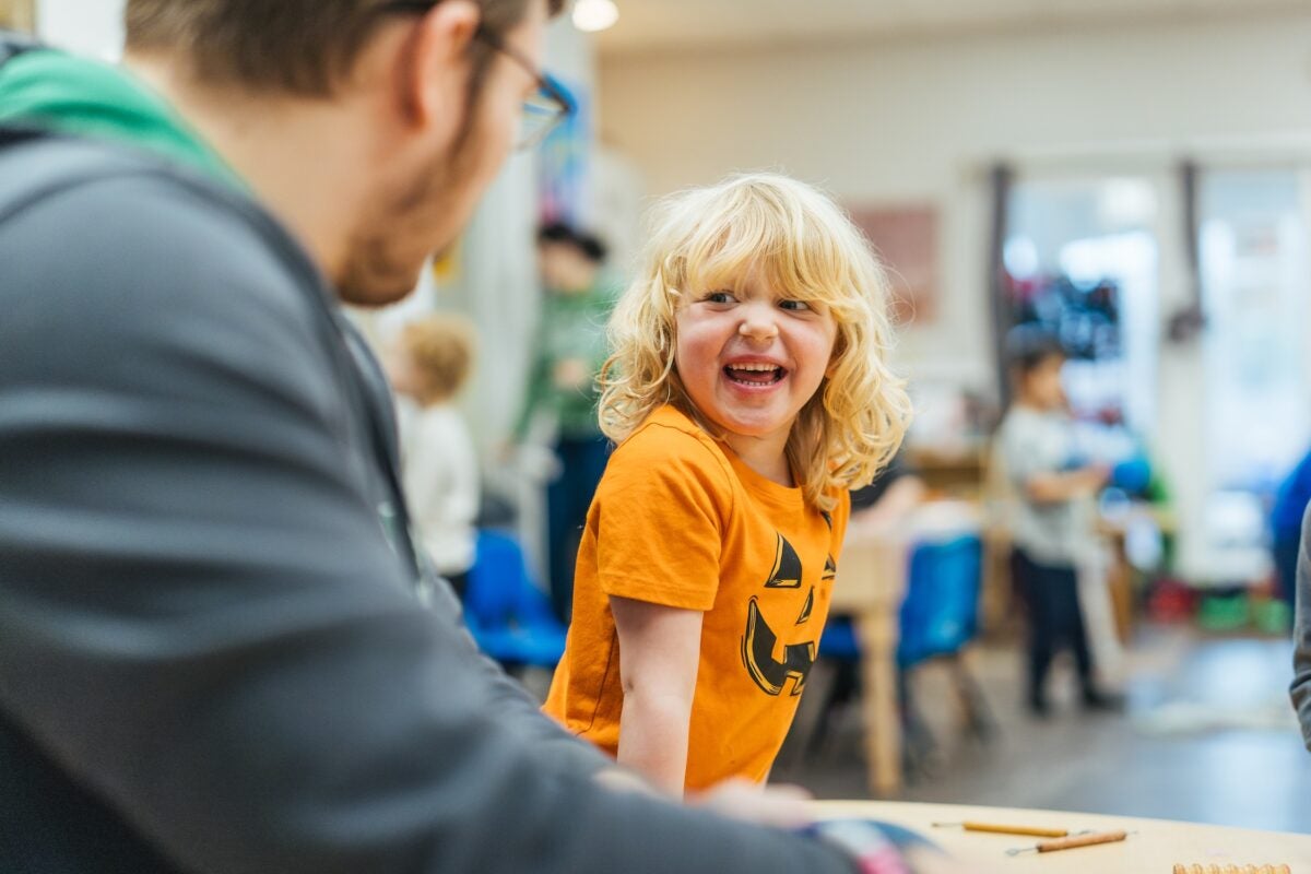 student looking up and smiling at a teacher