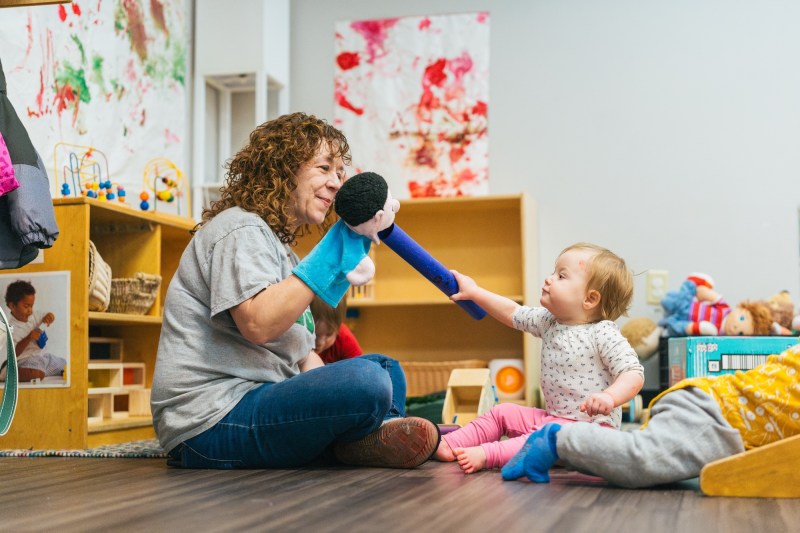teacher playing with infants with a puppet