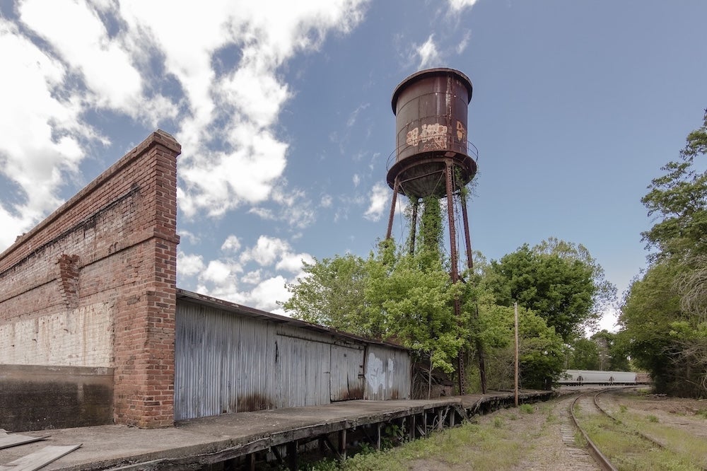 Giant water tower looms of abandoned factory in the deep south