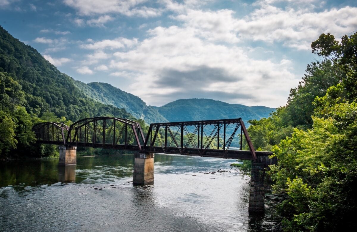 landscape photo of West Virginia including a river and a bridge