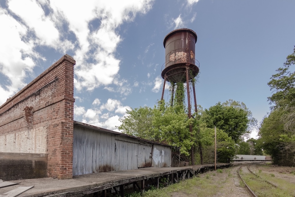 Giant water tower looms of abandoned factory in the deep south