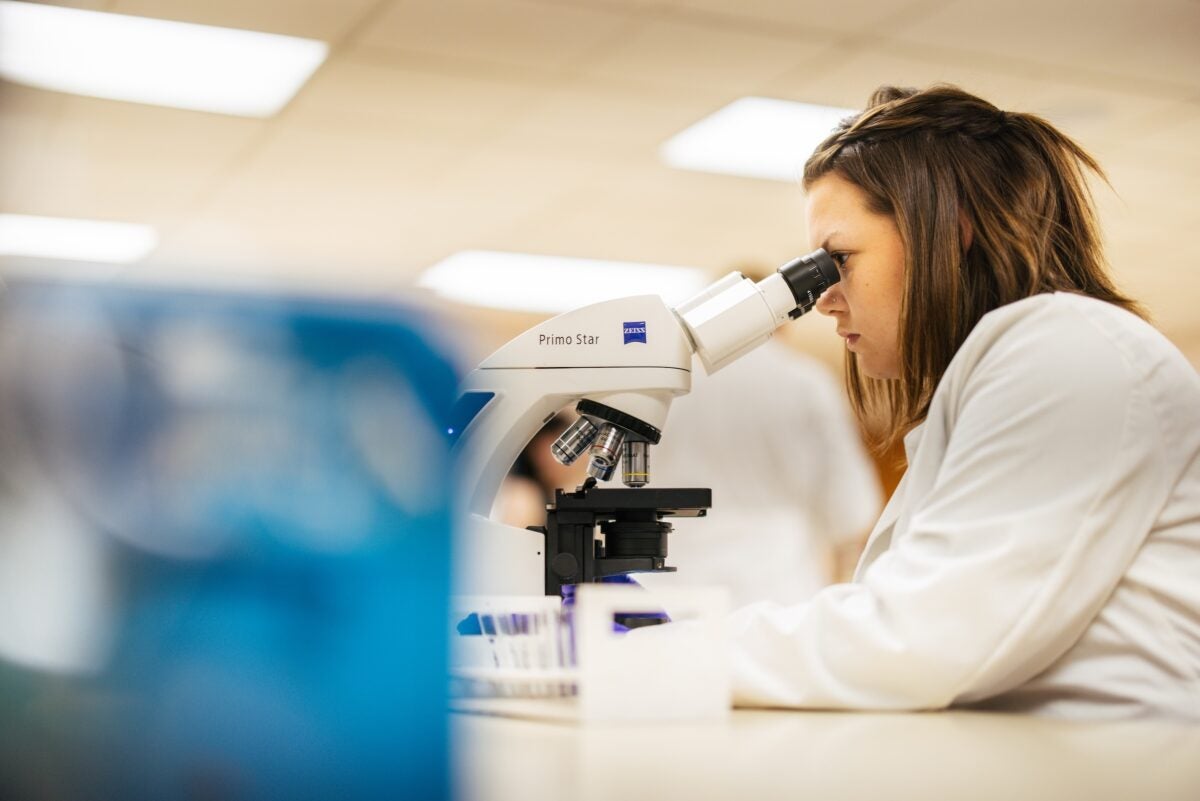 student looking through a microscope