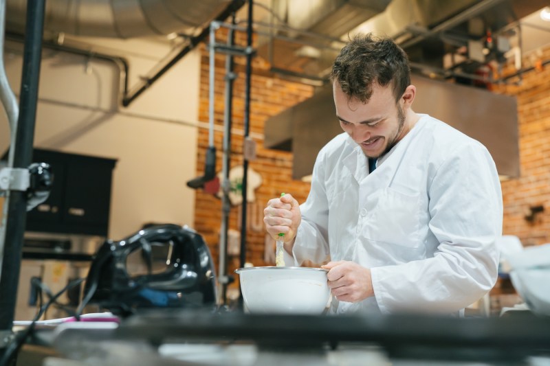 person mixing food in a dietetics kitchen