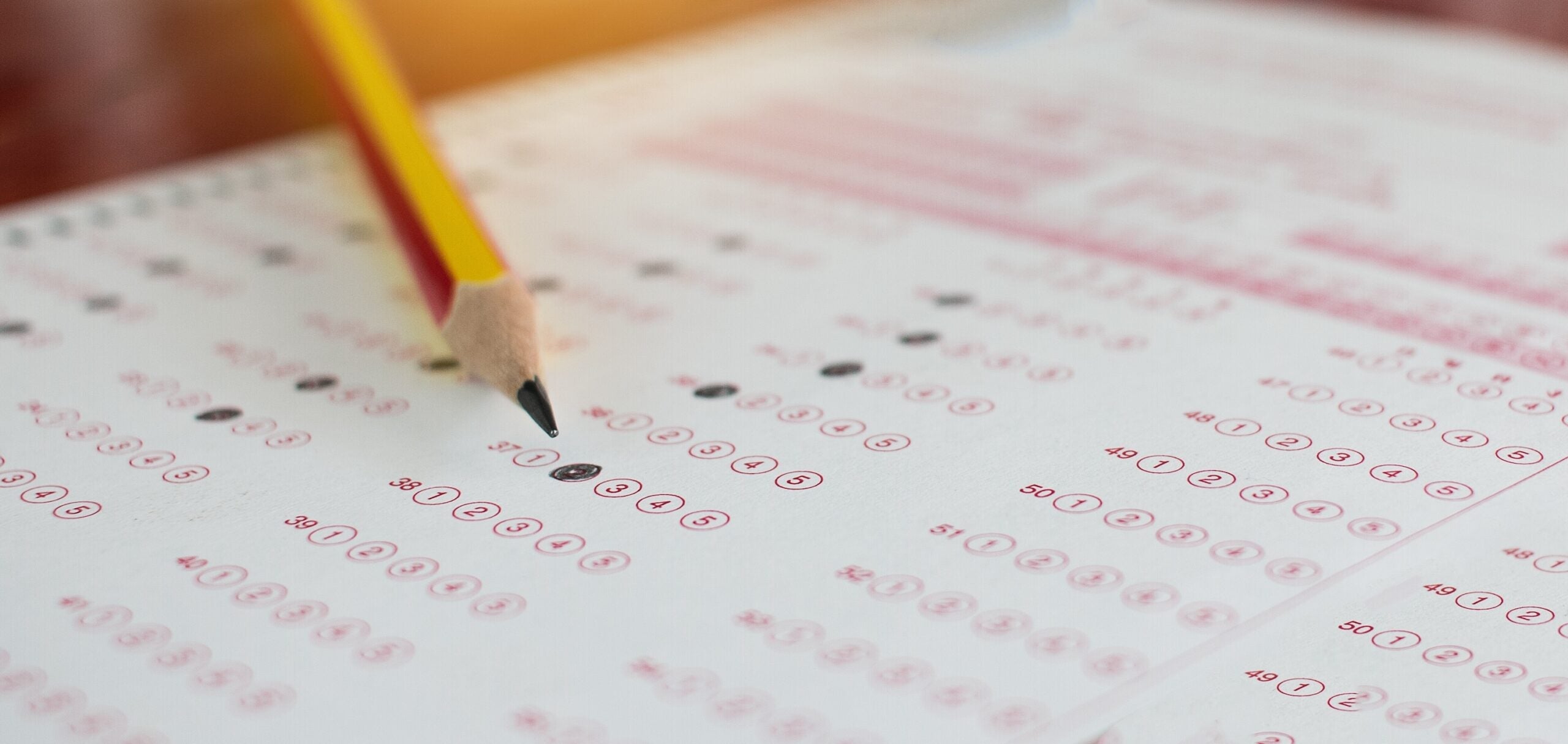 Standardized test exams form with answers bubbled in and color pencil resting on the paper test